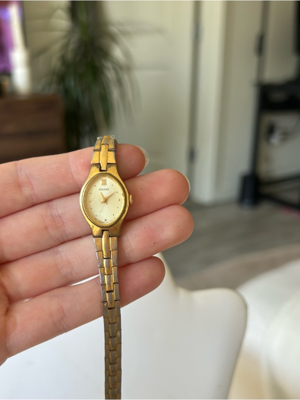 vintage Pulsar women's gold-tone wristwatch featuring an eye-shaped or oval case